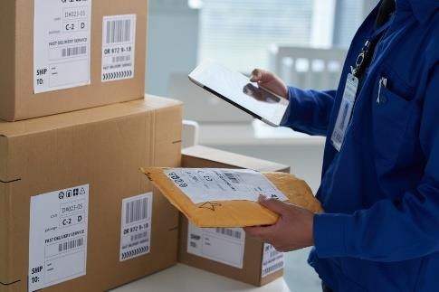 Warehouse officer checking cartons against a consignment list